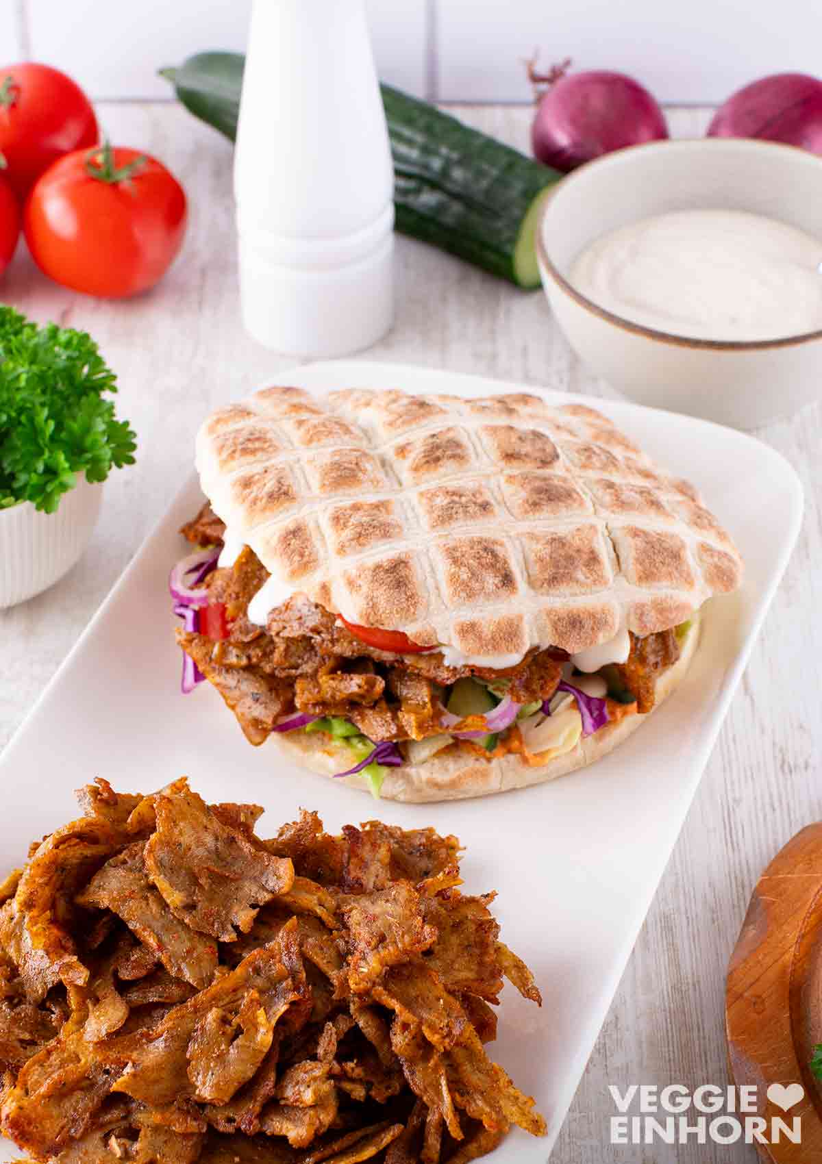 Vegane Dönertasche mit Seitan Dönerfleisch, Salat, Gurke und Dönersoße. Vegane Döner Tasche mit Rotkohl, Salat und Dönersoße