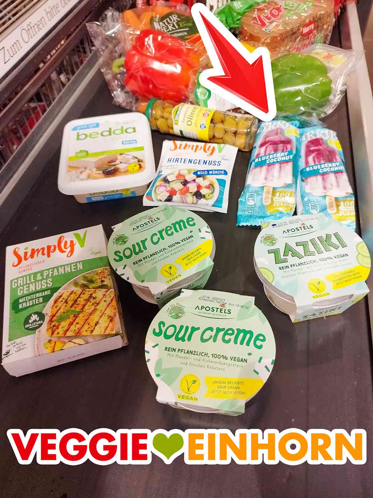 Likkies Blueberry Coconut, bedda Hirte, Simply V Hirtengenuss, Simply V Grill und Pfannengenuss, Apostels Veganer Zaziki, Apostels Vegane Sour Creme Zwei einzeln verpackte Likkies Blueberry Coconut auf dem Kassenband im Supermarkt