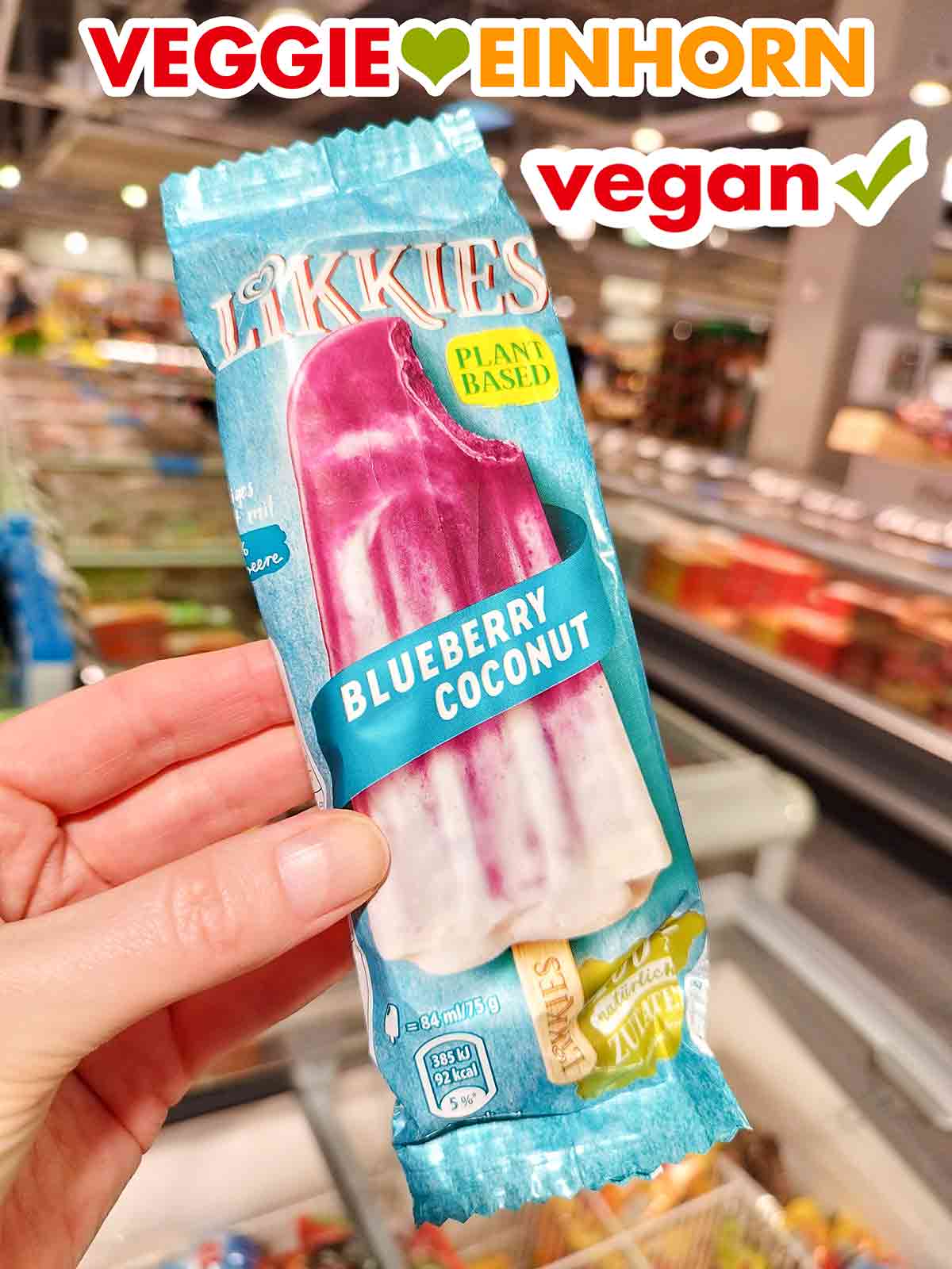 Langnese Likkies Blueberry Coconut im Combi Eine Hand hält ein Likkies Blueberry Coconut Eis im Supermarkt