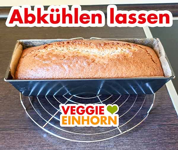 Der Kuchen kühlt in der Kastenbackform auf einem Abkühlgitter ab. Marzipankuchen in der Backform auf einem Kuchengitter