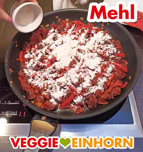 Zufügen des Mehls Mehl wird in die Pfanne gestreut