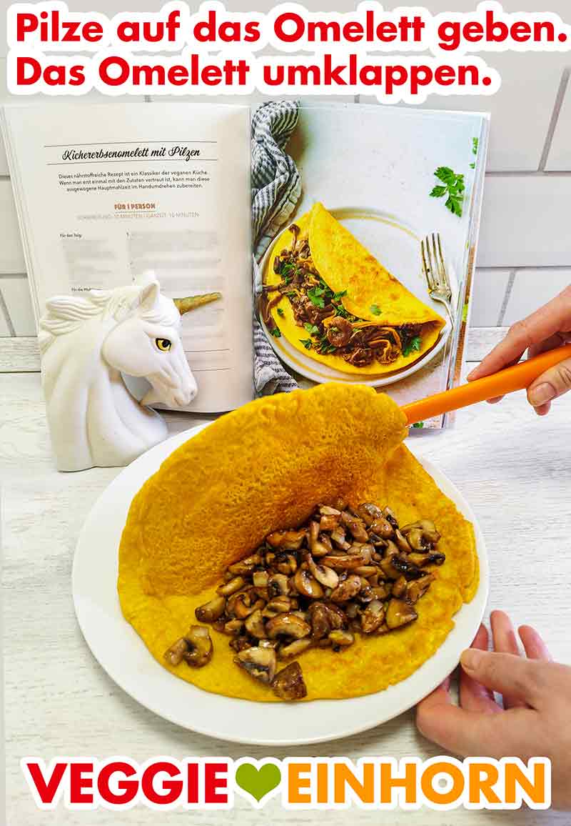 Umklappen des veganen Omelettes Das Kichererbsenomelett wird auf dem Teller über die Pilze umgeklappt