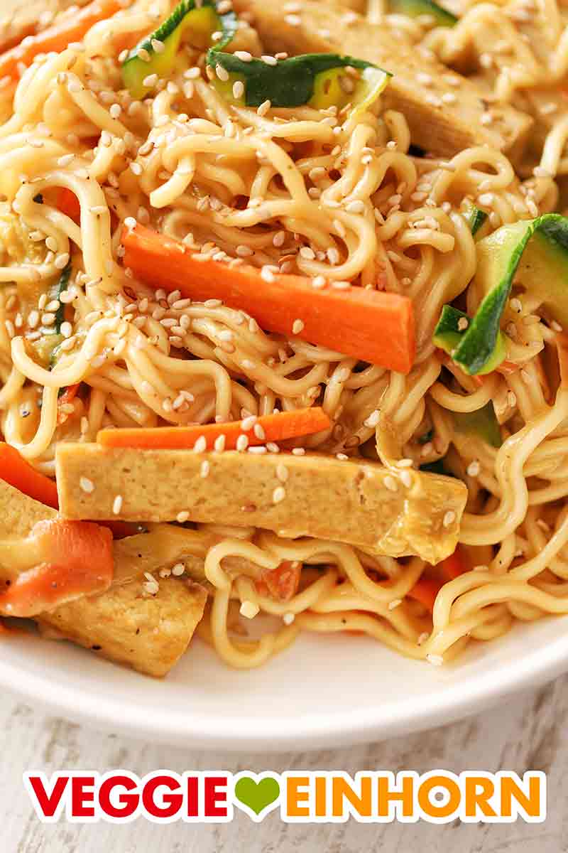 Die Mie Nudeln mit Tofu, Zucchini und Karotten sind lecker und gesund. Ein Teller Mie Nudeln mit Tofu, Zucchini, Möhren und Sesam