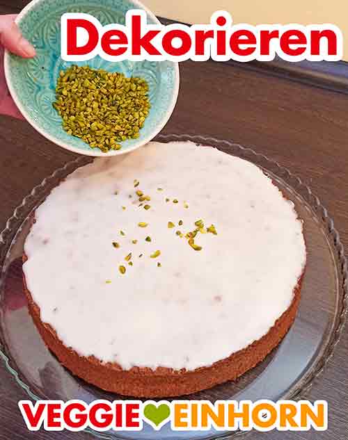 Den Möhrenkuchen mit Pistazien bestreuen als Deko Möhrenkuchen dekorieren mit gehackten Pistazien