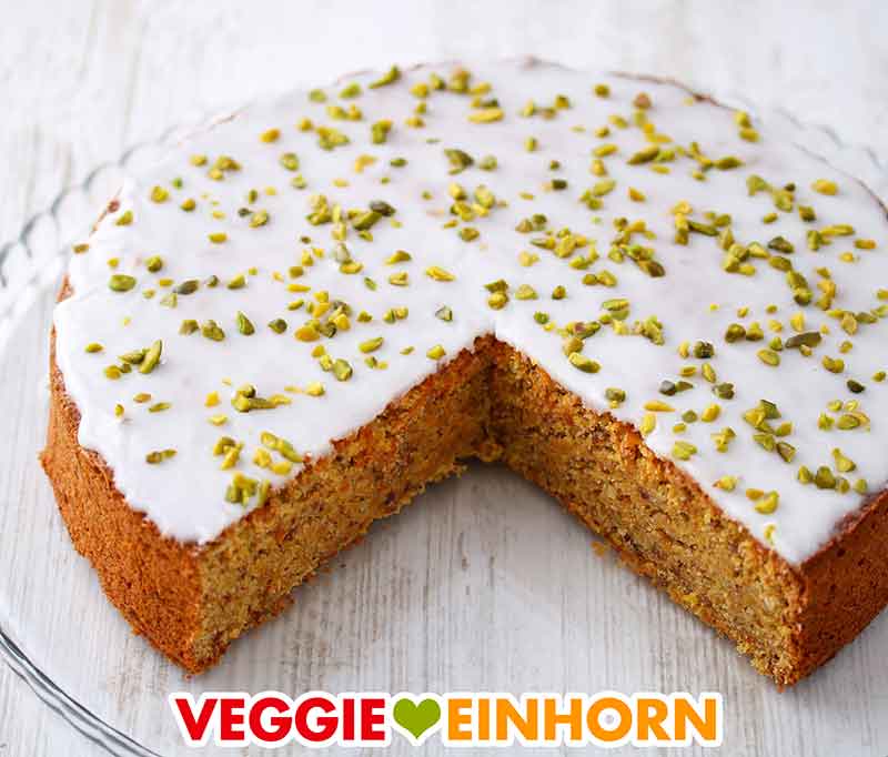 Der Möhrenkuchen ist mit Pistazien bestreut. Möhrenkuchen dekoriert mit gehackten Pistazien
