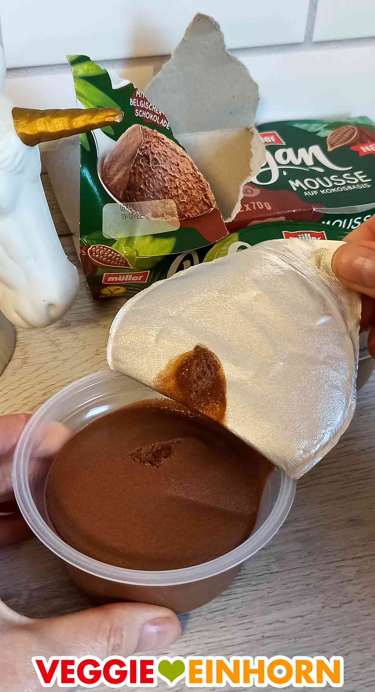 So sieht das Vegan Mousse Schoko von Müller aus. Der Deckel des Bechers wird geöffnet