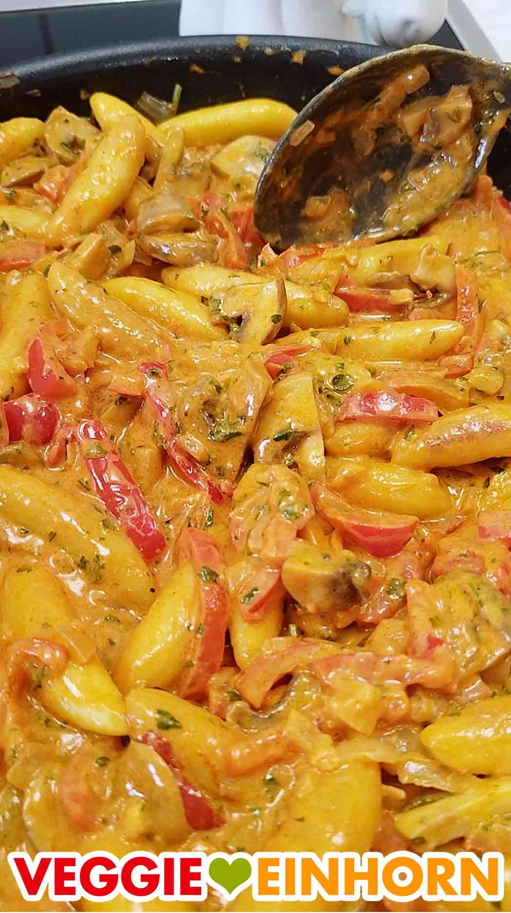 Das Gericht ist cremig durch die vegane Crème fraîche. Nahaufnahme der veganen Schupfnudelpfanne mit Paprika und Champignons
