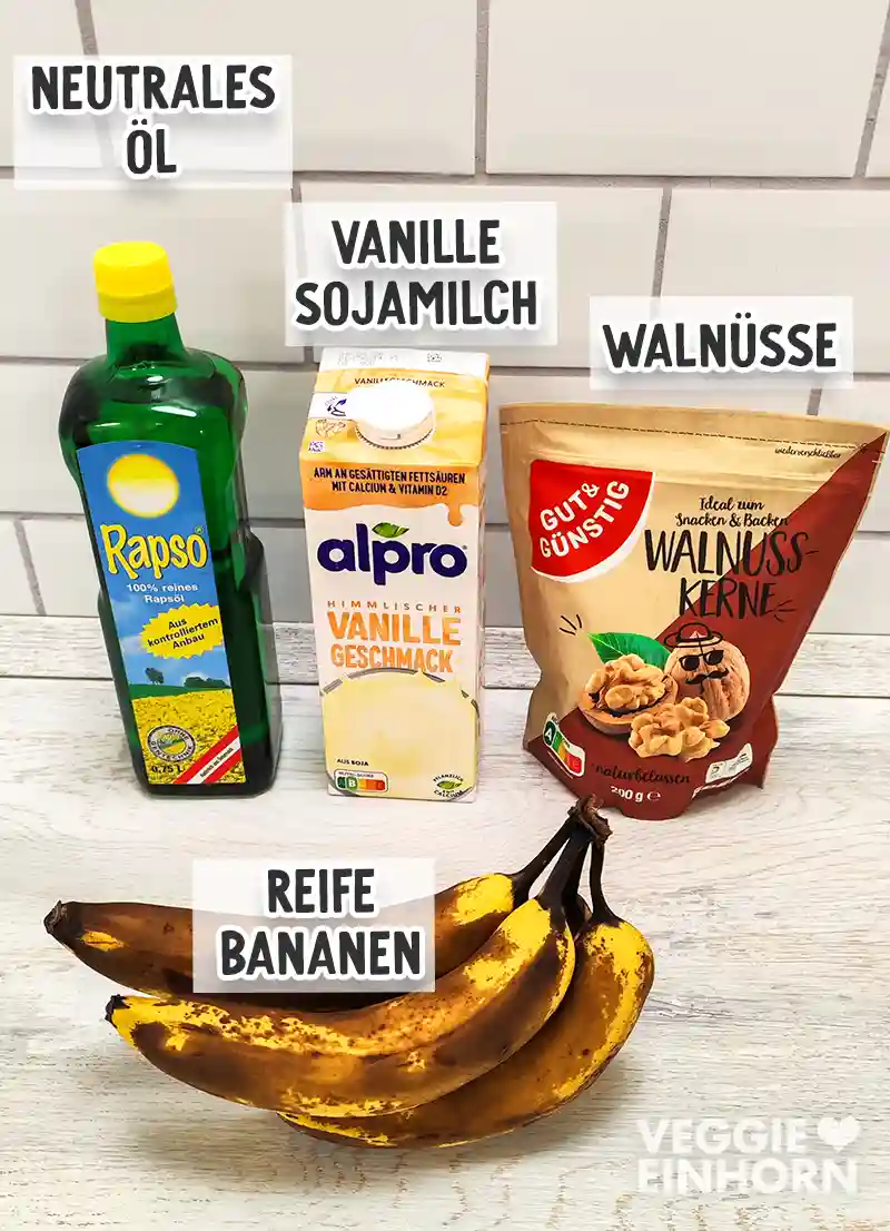 Flasche mit neutralem Öl, Vanille-Sojamilch, Walnüsse und sehr reife Bananen sind nebeneinander auf einem hellen Untergrund angeordnet.