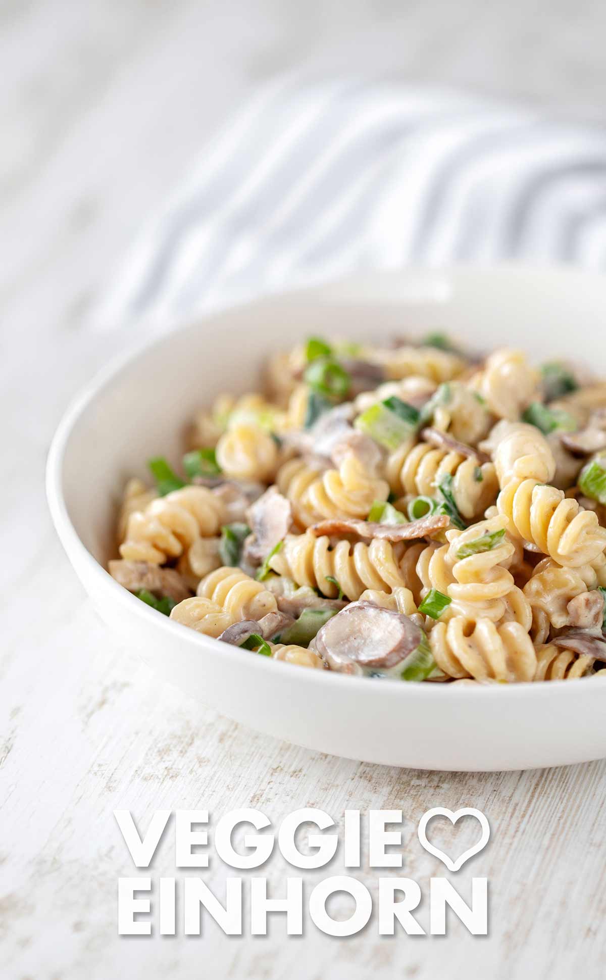 Die Nudeln mit veganem Speck und Pilzen sind ein einfaches und schnelles veganes Hauptgericht. Nudeln mit veganem Speck, Champignons und Frühlingszwiebeln auf einem Teller
