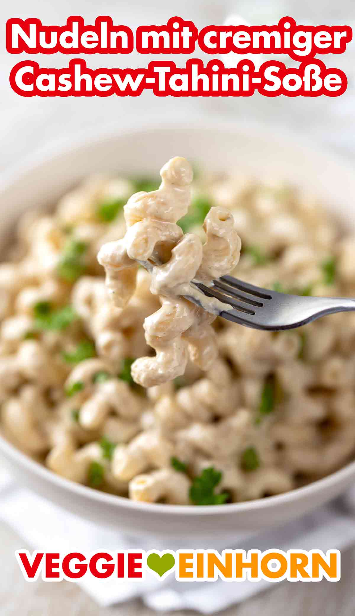 Die vegane Cashewsauce mit Tahini ist cremig und sahnig. Nudeln mit veganer Cashew-Tahini-Soße auf einer Gabel