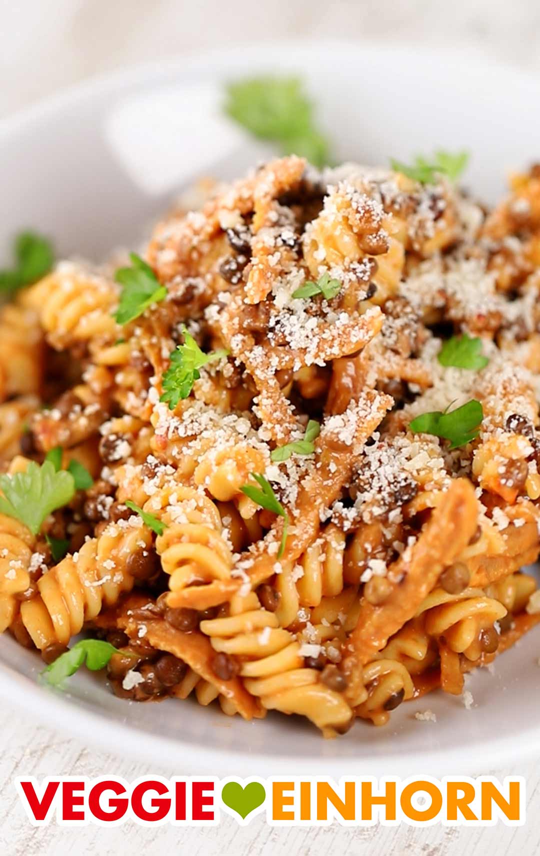 Die Nudeln mit Linsen, veganem Speck und veganer Parmesan-Alternative sind ein beliebtes italienisches Gericht. Pasta e Lenticchie mit Linsen, veganem Speck und veganem Parmesan-Ersatz
