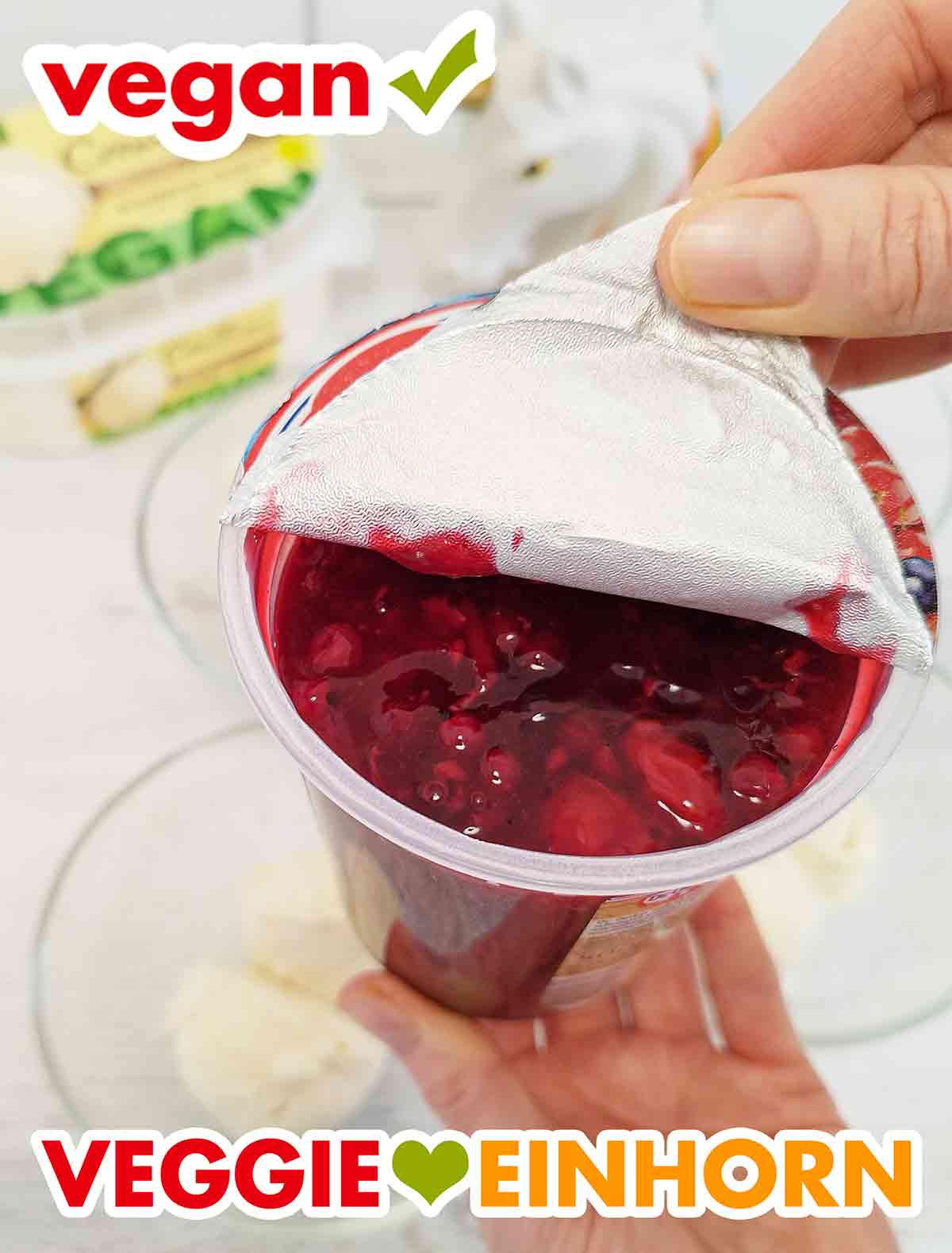 Die Folie des Bechers mit veganer roter Grütze wird abgezogen. Öffnen der Deckelfolie der veganen roten Grütze von Dr. Oetker