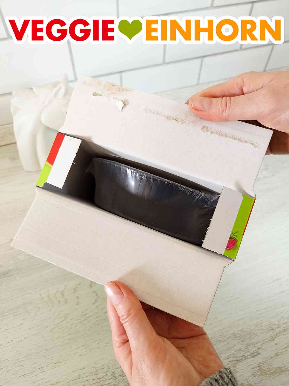 Öffnen des veganen Himbeer Mandel Kuchens von Coppenrath und Wiese Die Packung mit dem veganen Himbeer Mandel Kuchen von Coppenrath und Wiese wird geöffnet