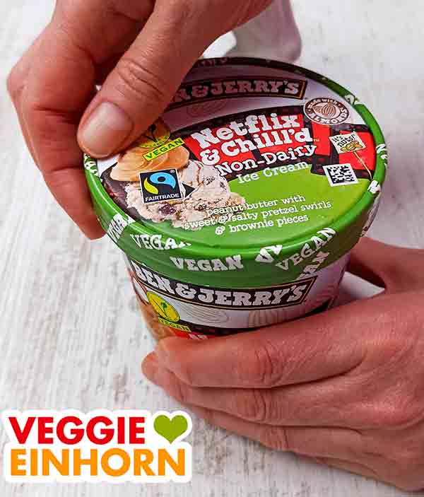 Der Becher mit veganer Eiscreme wird geöffnet. Öffnen des veganen Netflix & Chill'd von Ben & Jerry's