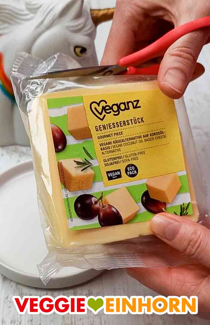 Die Folie des veganen Gouda Käse Blockes wird mit der Schere aufgeschnitten. Öffnen der Packung des Veganz Genießerstückes