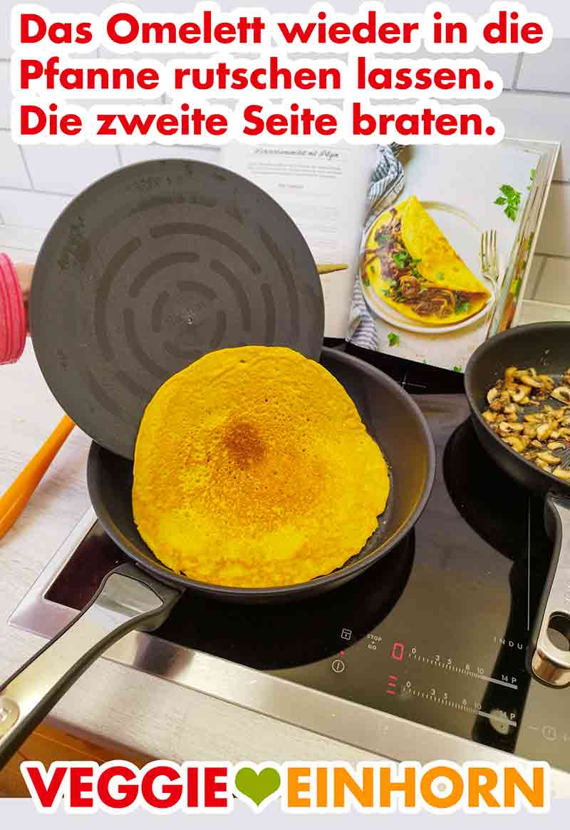 Das vegane Omelett zurück in die Pfanne geben und die zweite Seite braten. Das gewendete Omelett wieder in die Pfanne gleiten lassen.
