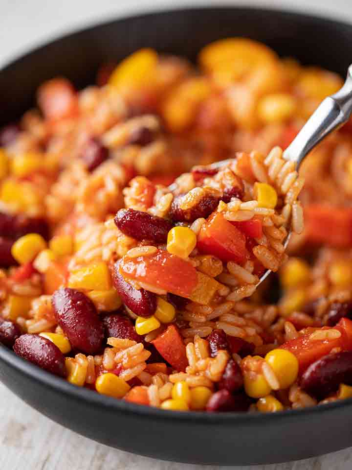 Teller mit One Pot Reis mit Paprika, Bohnen und Mais