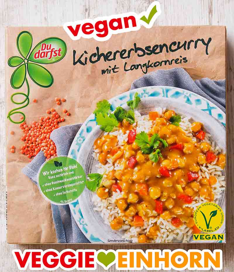 Das Kichererbsencurry Fertiggericht ist vegan. Eine Packung veganes Kichererbsencurry von Du Darfst auf einem Tisch