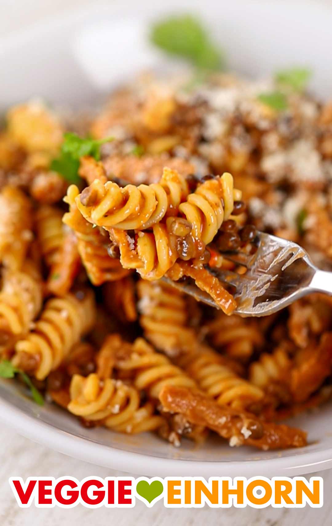 Pasta e Lenticchie mit Fusilli und veganem Speck Pasta mit Linsen und veganem Speck auf einer Gabel