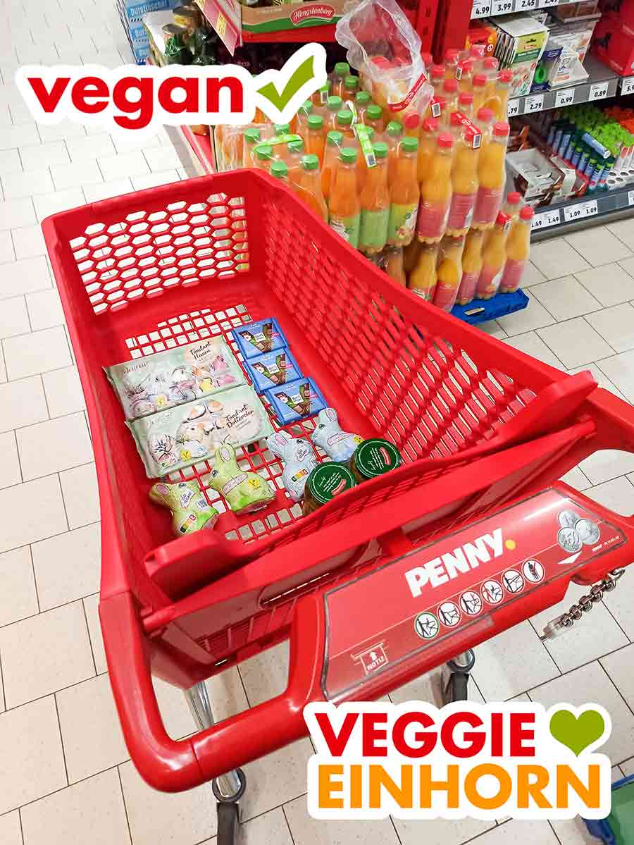 Bei Penny gibt es leckere vegane Schokohasen und Ostersüßigkeiten. Ein roter Einkaufswagen von Penny mit veganen Süßigkeiten für Ostern
