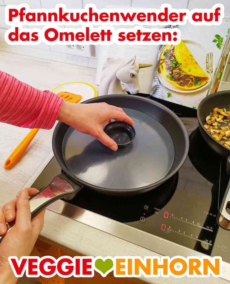 Den Pfannkuchenwender auf das Omelett setzen. Pfannkuchenwender auf dem Omelett in der Pfanne