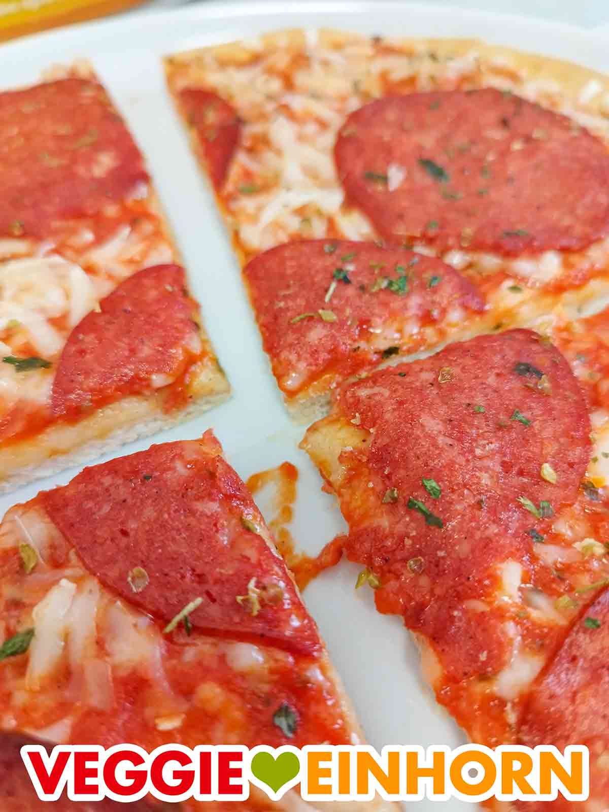 Die Pizza Ristorante al Salame Vegano ist in vier Stücke geschnitten. Nahaufnahme der geschnittenen veganen Salami Pizza Ristorante von Dr. Oetker