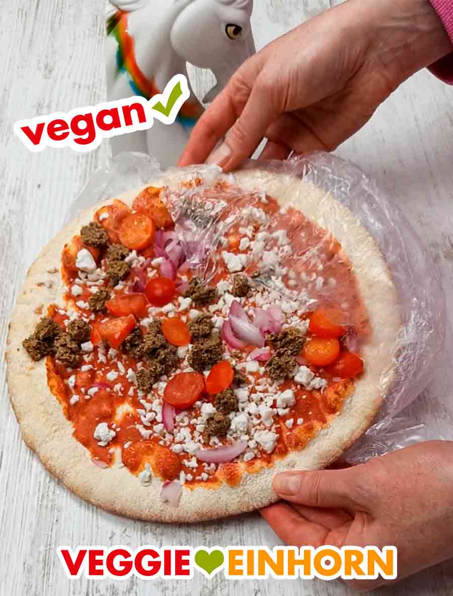 Die Folie der veganen Thunfisch Tiefkühlpizza wird entfernt. Entfernen der Folie von der veganen Pizza Tu Nah