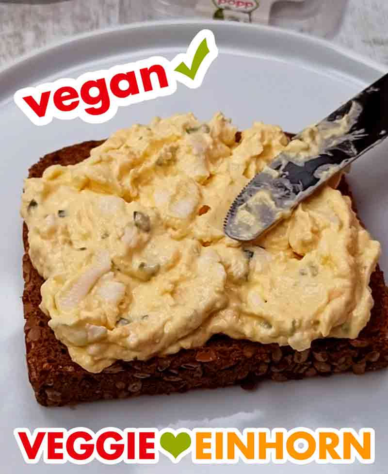 Hier sieht man die leckeren Stücke von veganem Ei. Der vegane Eiersalat wird auf eine Scheibe Brot gestrichen.