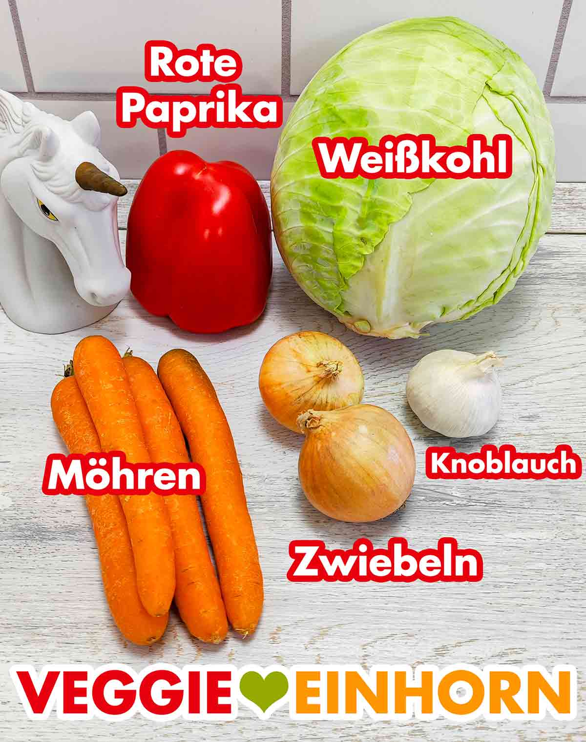 Eine rote Paprikaschote, ein Kopf Weißkohl, Karotten, Zwiebeln, eine Knoblauchknolle Rote Paprika, Weißkohl, Möhren, Zwiebeln, Knoblauch