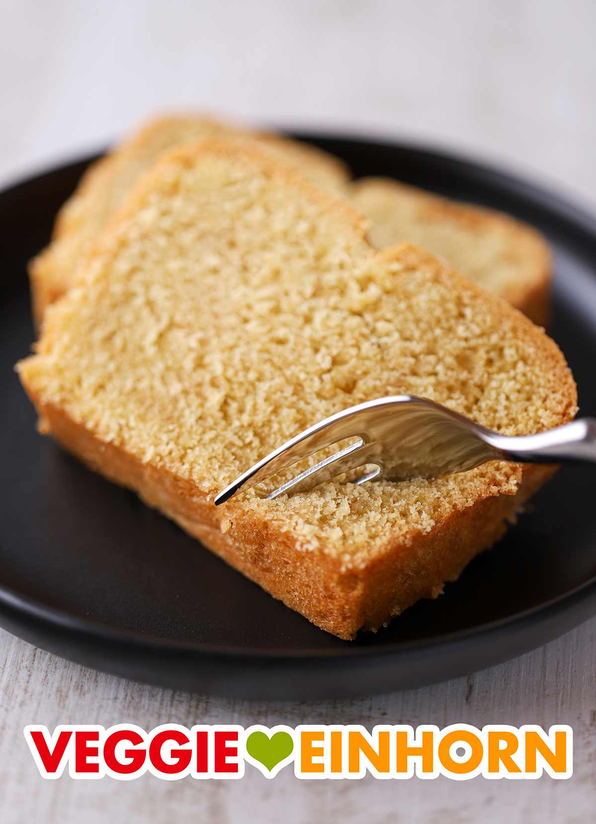Der Kuchen aus Rührteig mit veganer Butter und Eiersatz ist sehr beliebt. Zwei Stücke Rührkuchen auf einem Teller mit einer Kuchengabel