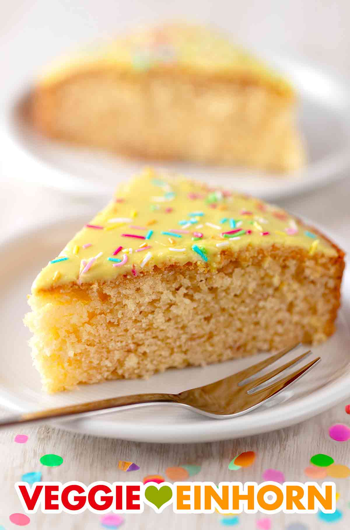 Der einfache Fantakuchen ist vegan und saftig. Zwei Kuchenteller mit veganem Fantakuchen aus der Springform