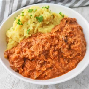 Ein Teller mit Sauerkrautpfanne mit veganem Hack und Champignons, als Beilage Kartoffelpüree.
