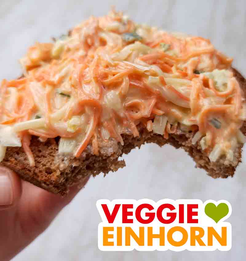 Der vegane Farmersalat von Popp Feinkost schmeckt hervorragend. Angebissene Brotscheibe mit veganem Farmersalat von Popp