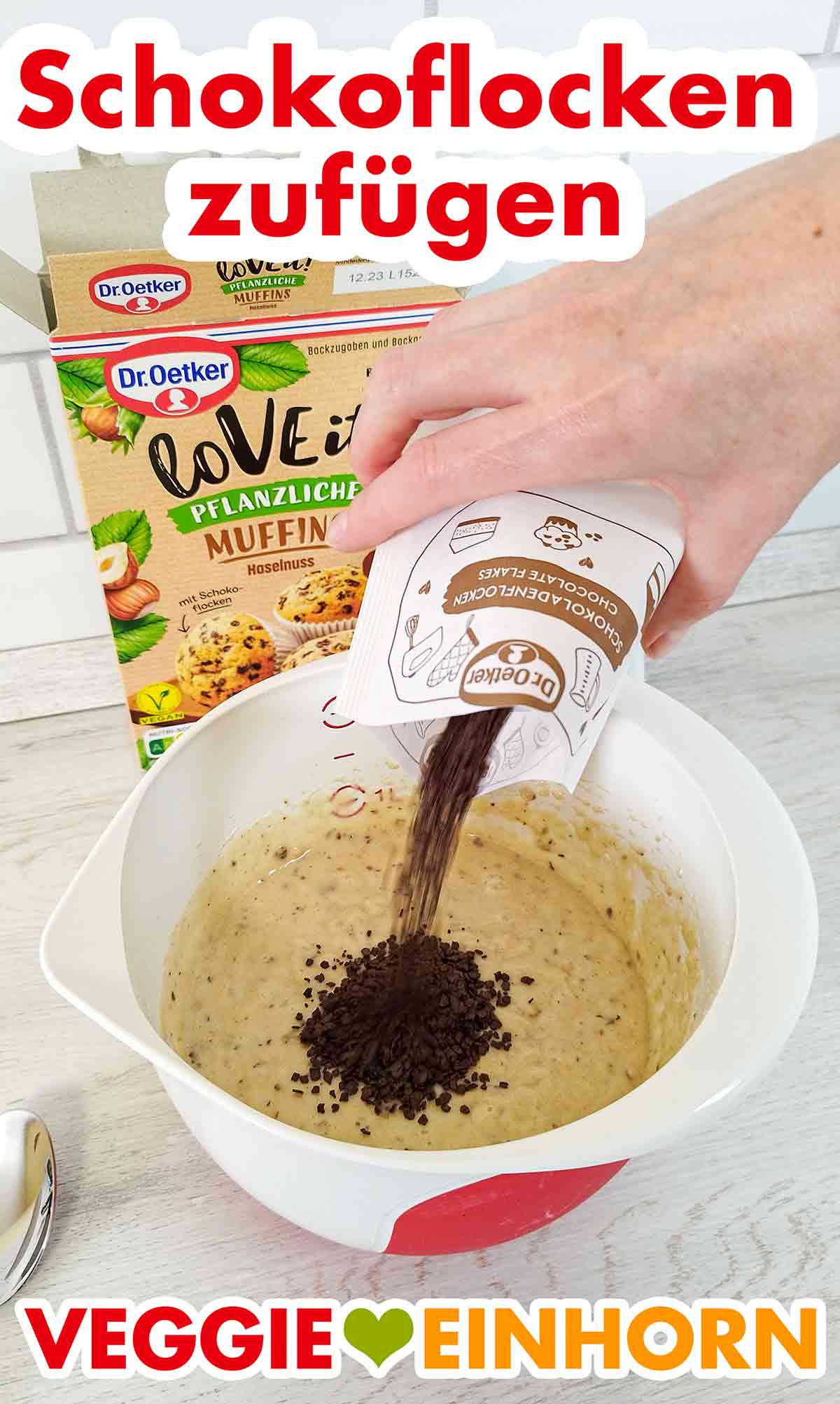 Zufügen der veganen Schokoflocken. Die Schokoflocken werden zum Muffinteig zugefügt.