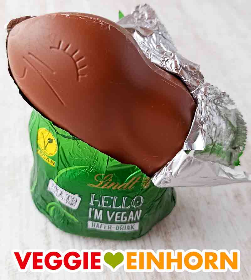 Der vegane Lindt Hello Schoko Osterhase mit halb entfernter Folie. Der vegane Lindt Hello Hase wird ausgepackt