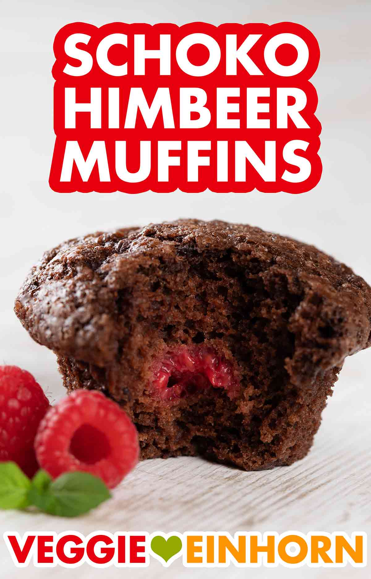 Veganer Schoko Himbeer Muffin Angebissener veganer Schokomuffin mit einer Himbeere drin