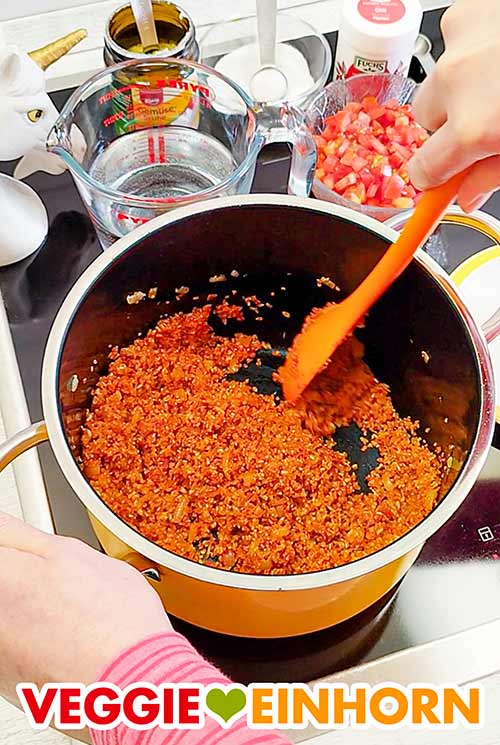 Beim Anbraten den Bulgur gut mit dem Tomatenmark vermischen. Anbraten des Bulgurs und des Tomatenmarks für den Tomatenbulgur