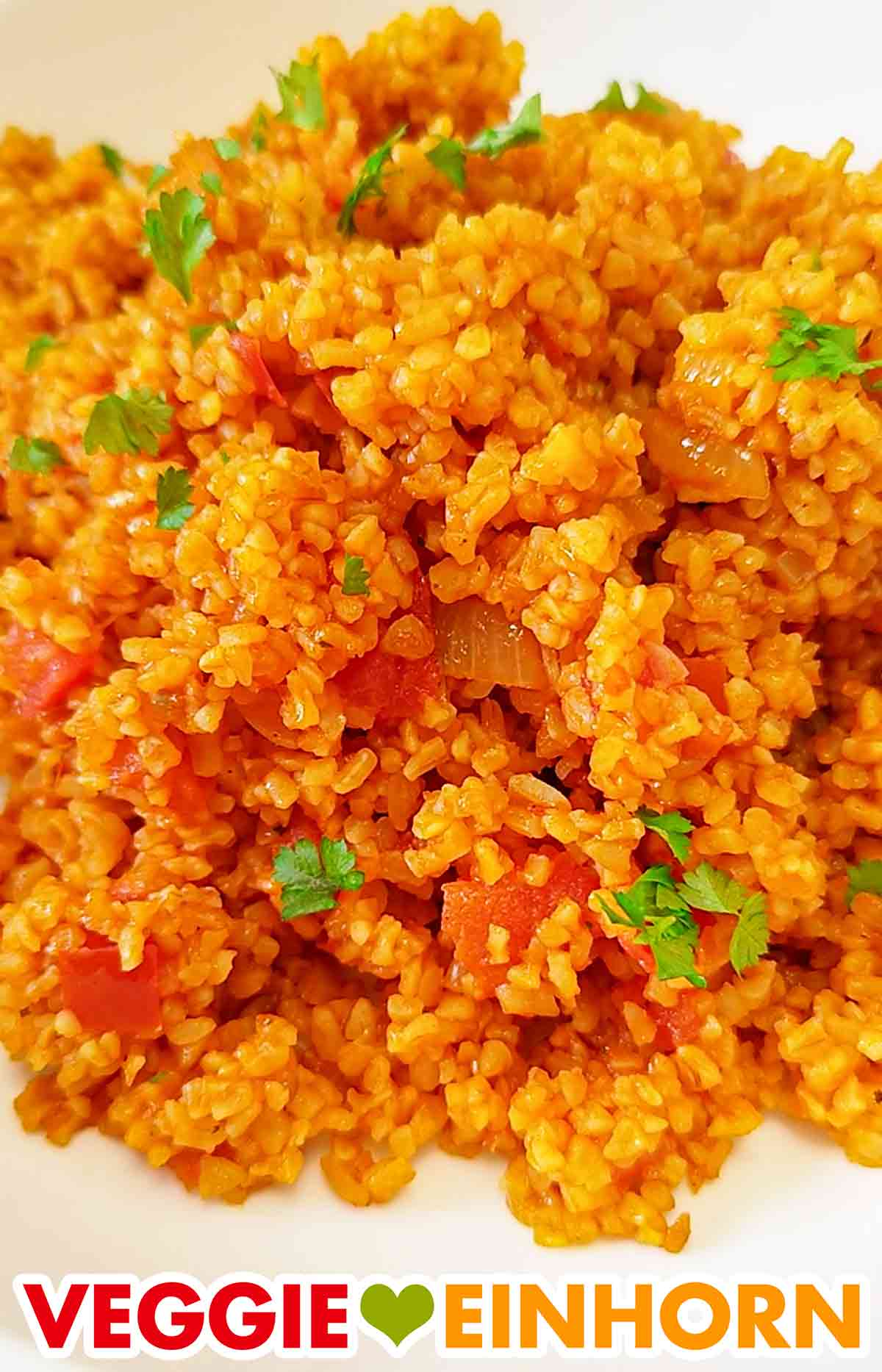 Tomaten Bulgur ist eine sehr beliebte Beilage. Nahaufnahme von Tomatenbulgur mit frischer Petersilie