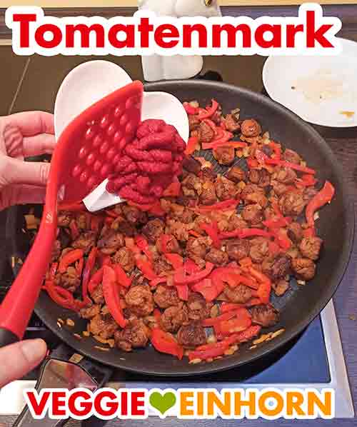 Zufügen von Tomatenmark Tomatenmark wird in die Pfanne zugefügt
