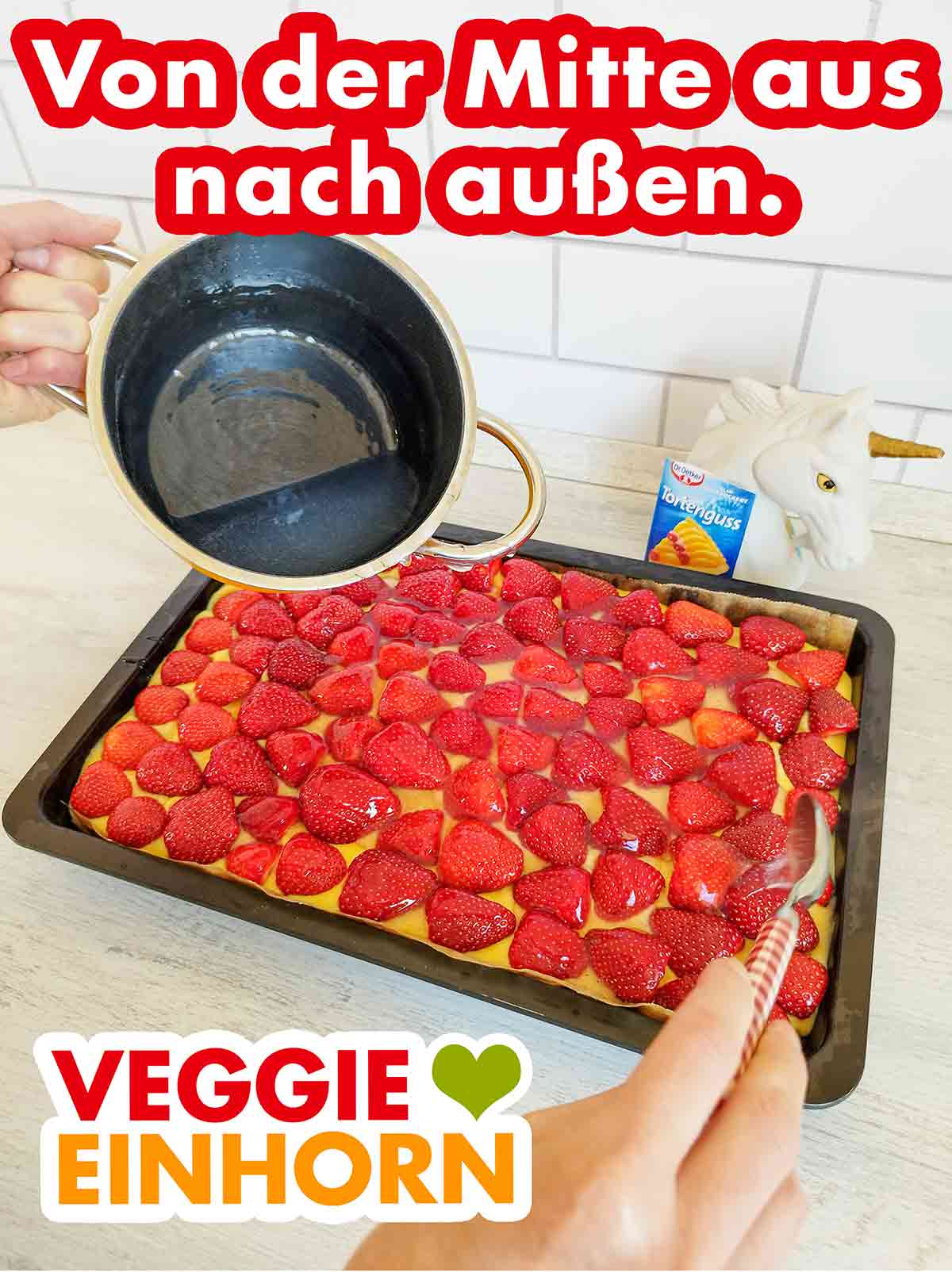 Von innen nach außen verteilen. Mit einem Esslöffel wird der vegane Tortenguss von Dr. Oetker auf dem Kuchen verteilt.