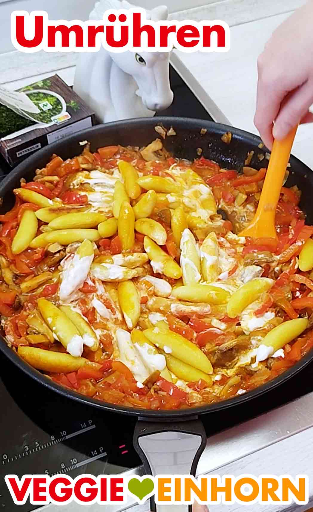 Umrühren der veganen Schupfnudel Pfanne mit veganer Crème fraîche Die Schupfnudelpfanne mit veganer Crème fraîche wird umgerührt.