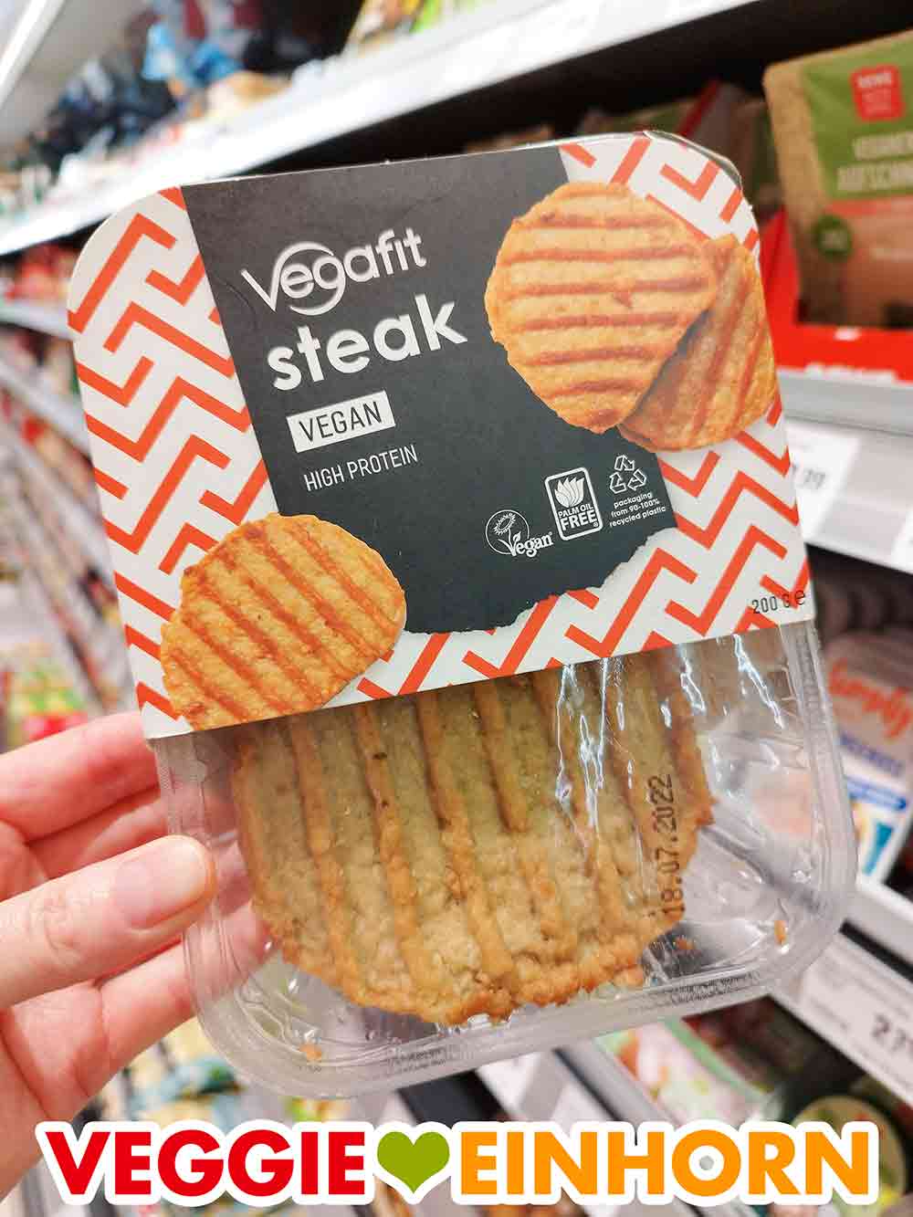 Die Vegafit Steaks im Rewe Eine Hand hält eine Packung Vegafit Steaks im Supermarkt