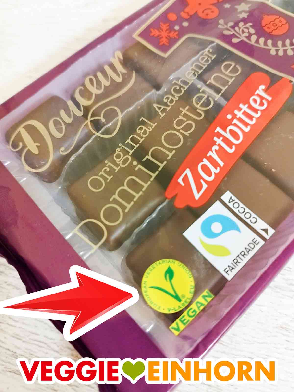 Auf den Original Aachener Dominotsteinen Zartbitter von Penny Douceur ist ein veganes V-Label. Vegan Logo auf der Packung der Zartbitter Dominosteine von Penny Douceur