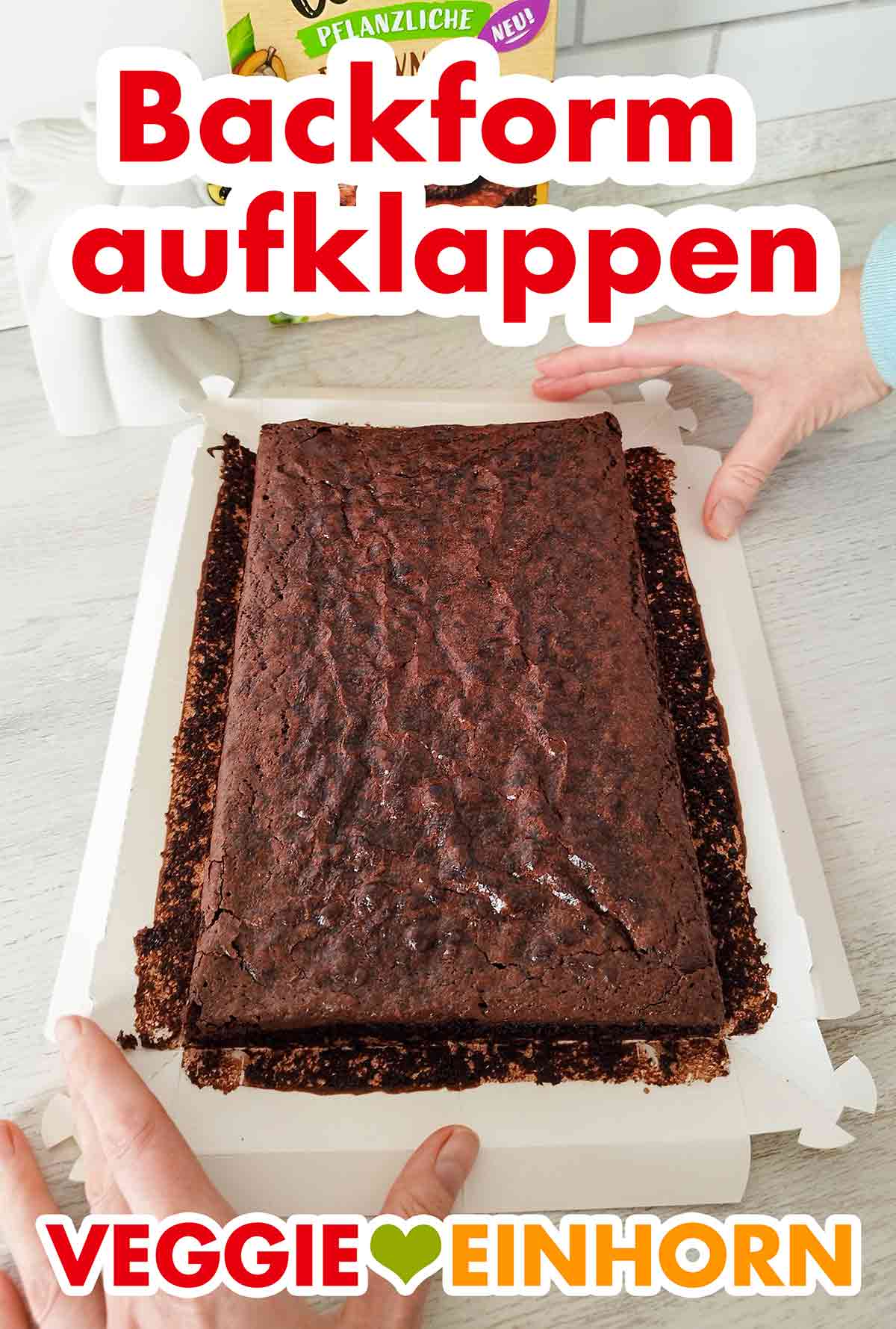Wenn die Brownies ganz abgekühlt sind, wird die Form gelöst und aufgeklappt. Die aufgeklappte Backform mit den fertigen veganen Brownies von Dr. Oetker