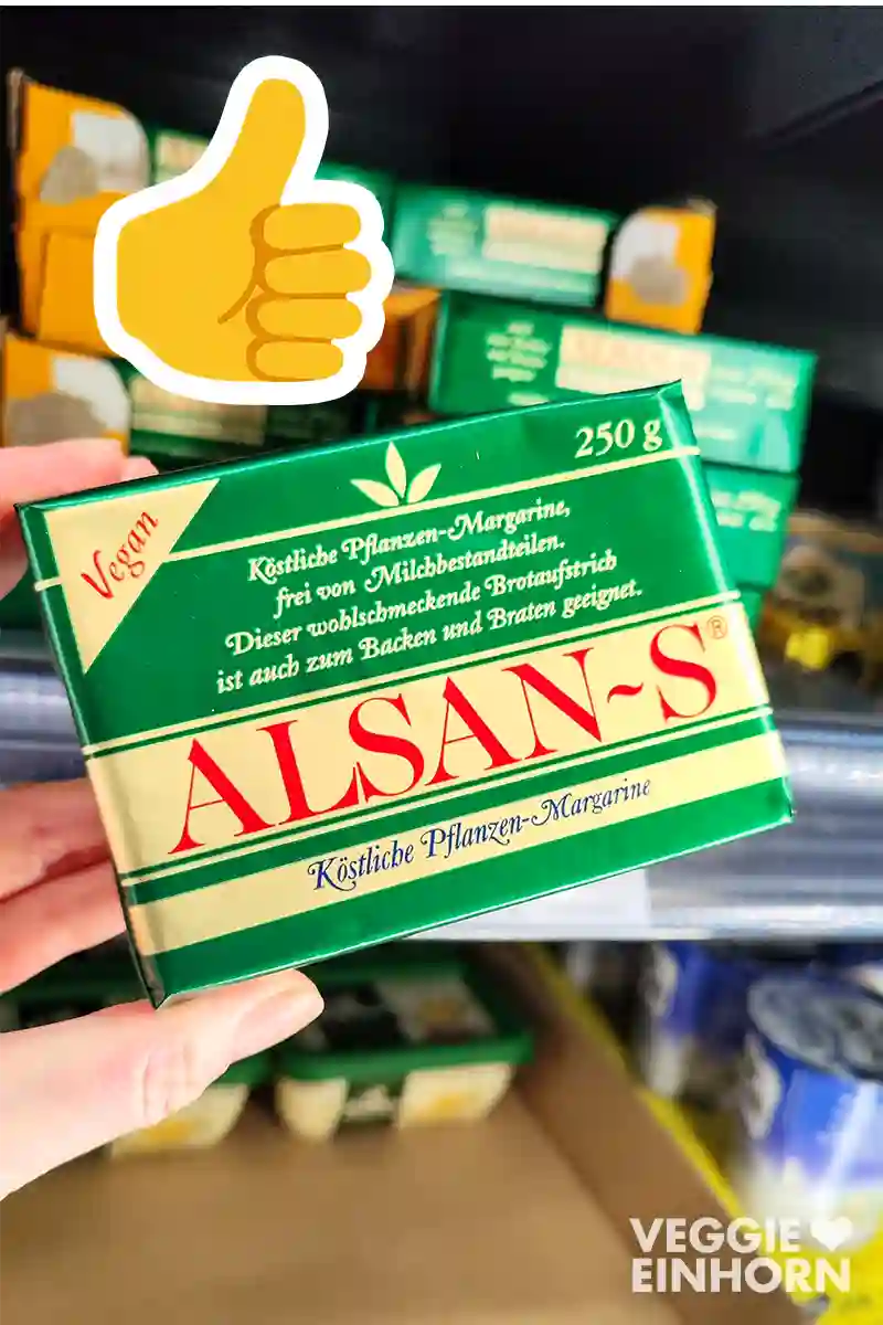 Eine Hand hält eine Packung vegane Butter der Marke Alsan-S. Oben links ist ein Daumen-hoch-Emoji.