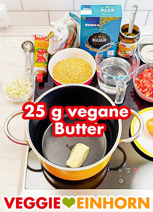 25 g vegane Butter werden im Topf erhitzt. Topf mit veganer Butter auf dem Herd mit weiteren vorbereiteten Zutaten für den Tomaten Bulgur
