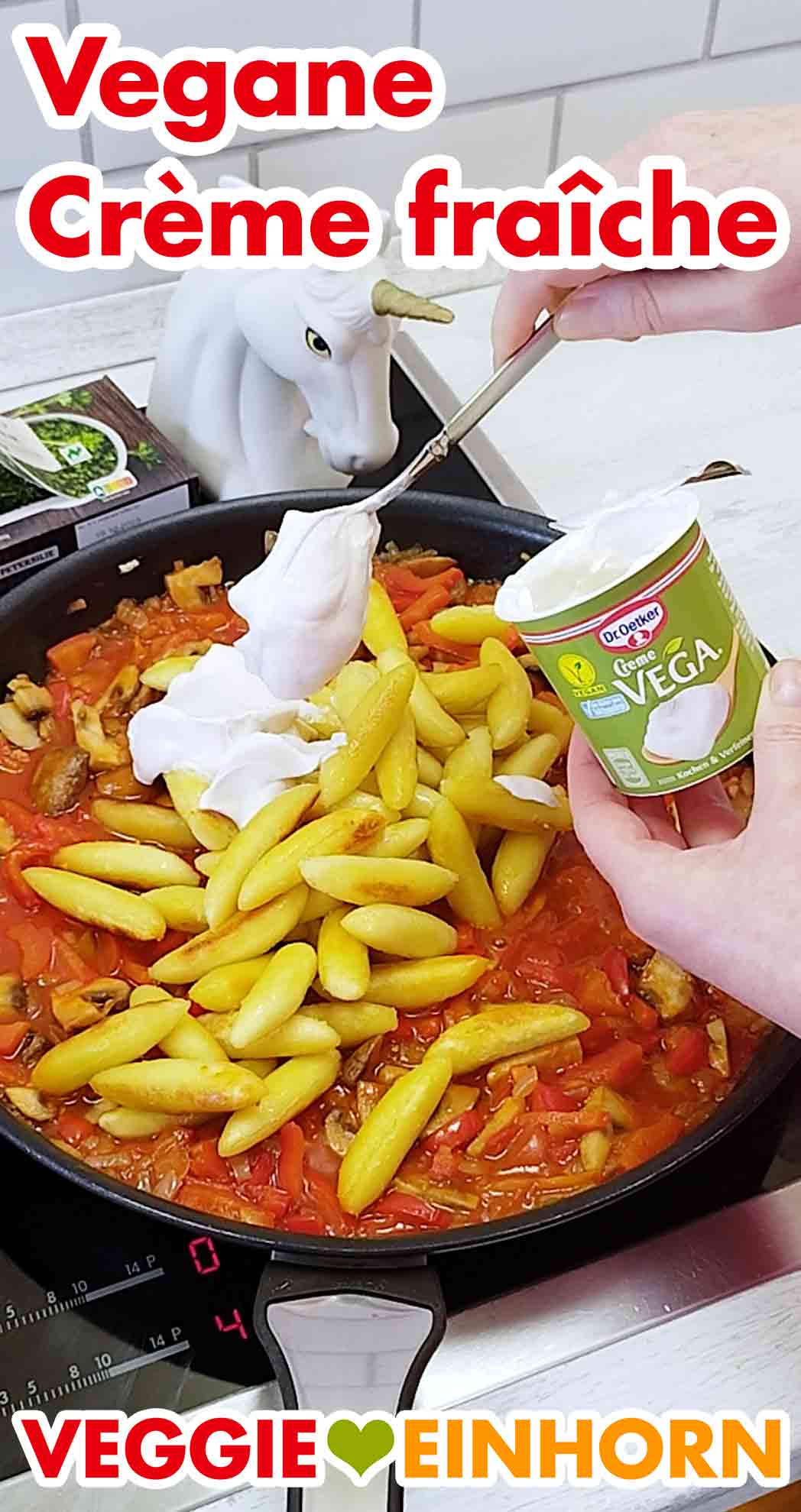 Vegane Crème fraîche wird zu der Schupfnudelpfanne mit Paprika und Champignons zugefügt. Zufügen von veganer Crème fraîche zu der Schupfnudelpfanne