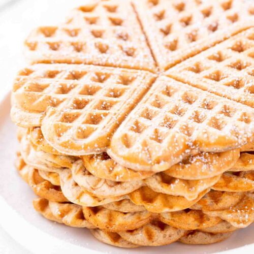 Mehrere vegane Dinkelwaffeln auf einem Teller, seitlich fotografiert.