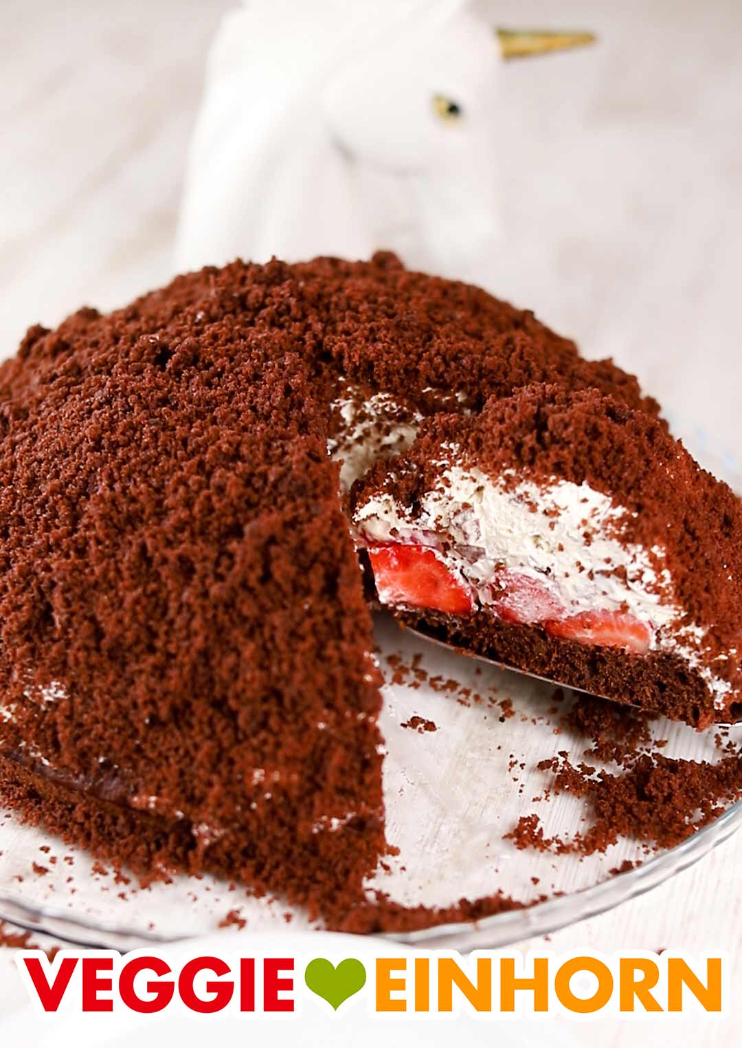 Die vegane Maulwurftorte mit Erdbeeren wird serviert. Ein Stück veganer Maulwurfkuchen mit Erdbeeren auf einem Tortenheber