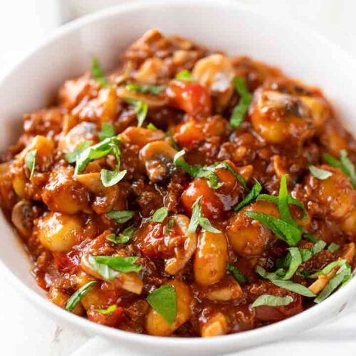 Vegane Gnocchi Pfanne mit Hackfleisch, Pilzen und Tomaten auf einem Teller